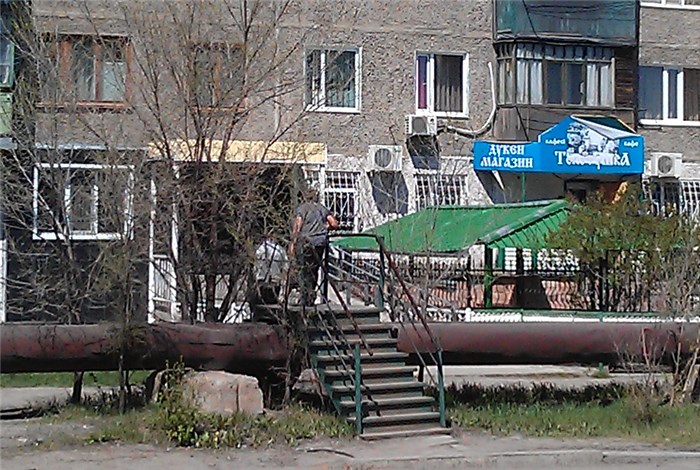 カザフスタンの水道管の上を渡る人（拡大）